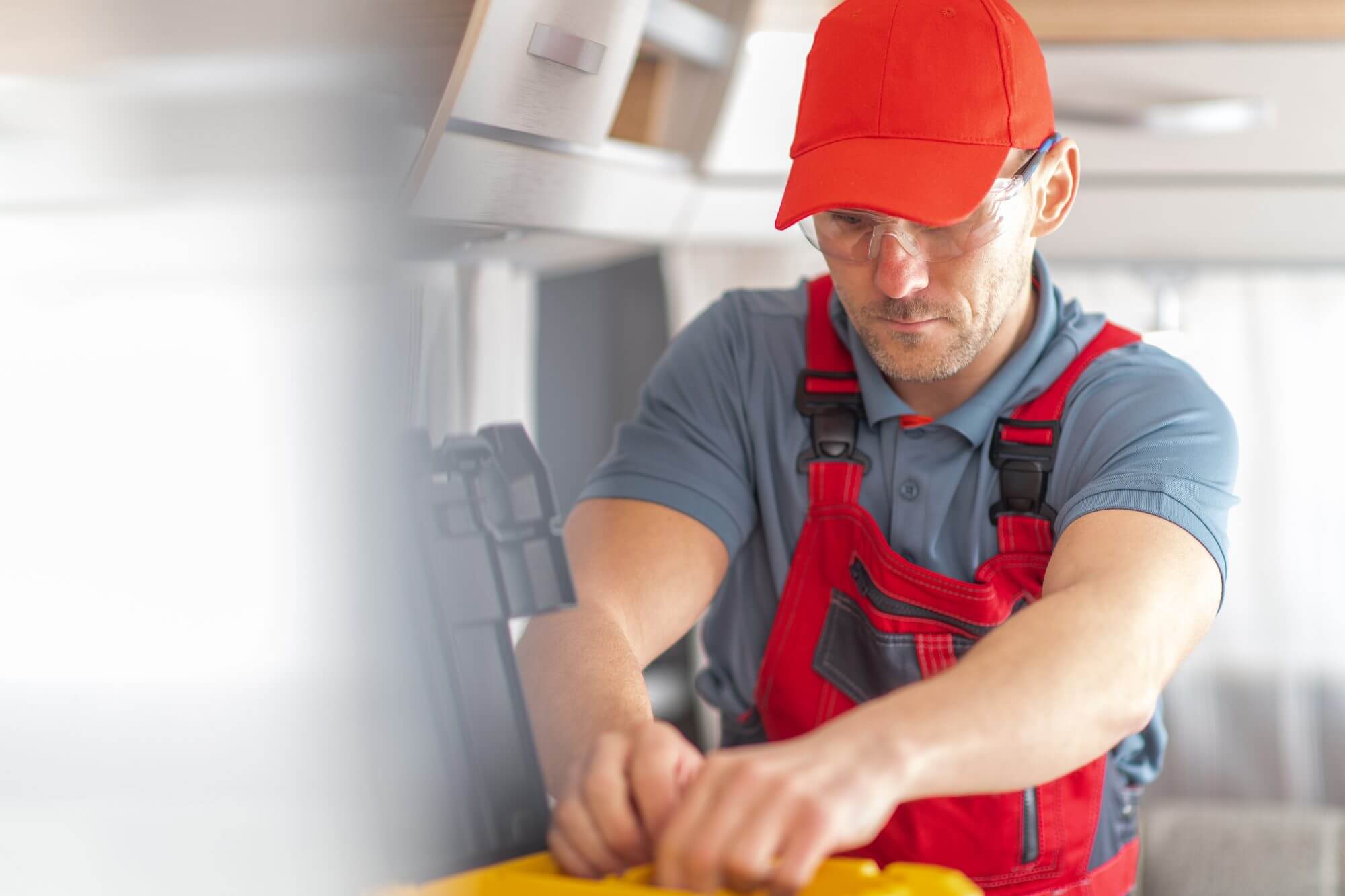Caucasian RV Industry Technician In His 40s Inside Modern Travel Trailer Performing Scheduled Service of Recreational Vehicle.