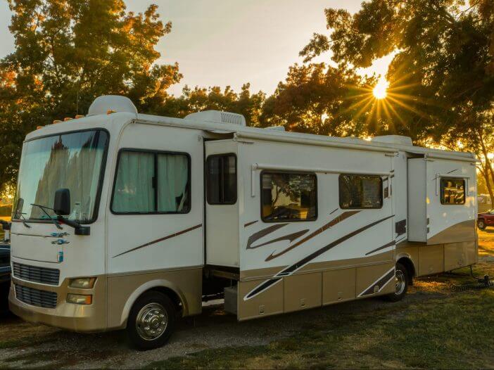 Camping at campsite in Rv motorhome with sunburst trees and grass