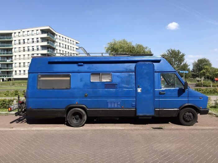 Almere, the Netherlands - August 22, 2019: Hand painted Blue 1980's Fiat camper van parked by the side of the road. Nobody in the vehicle.