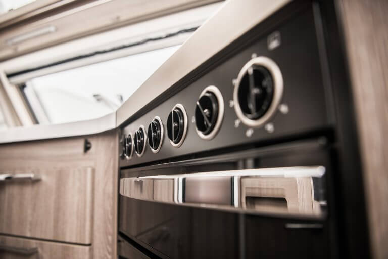 Modern RV Kitchen Oven Closeup. Cooking Inside Motorhome Theme.