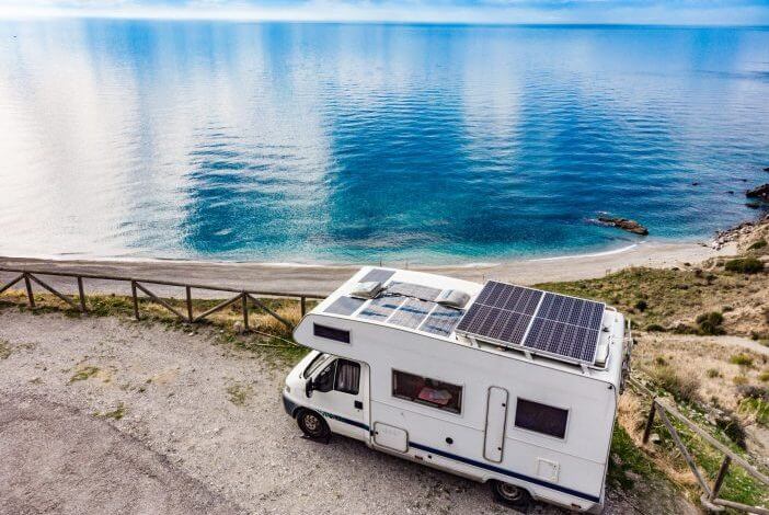 Caravan with solar panels on roof camping on cliff sea coast. Mediterranean region of Nerja, Costa del Sol in Andalusia, Spain.