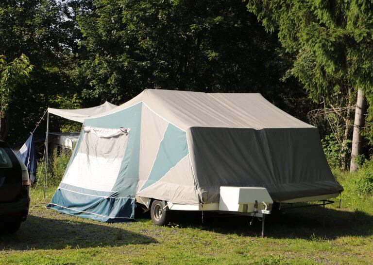 an old folding caravan on a campsite
