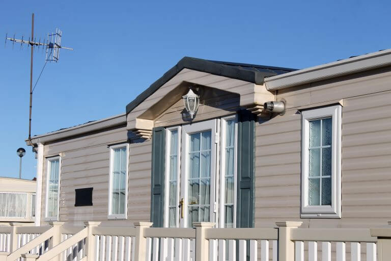 Exterior of luxurious modern caravan with blue sky background.