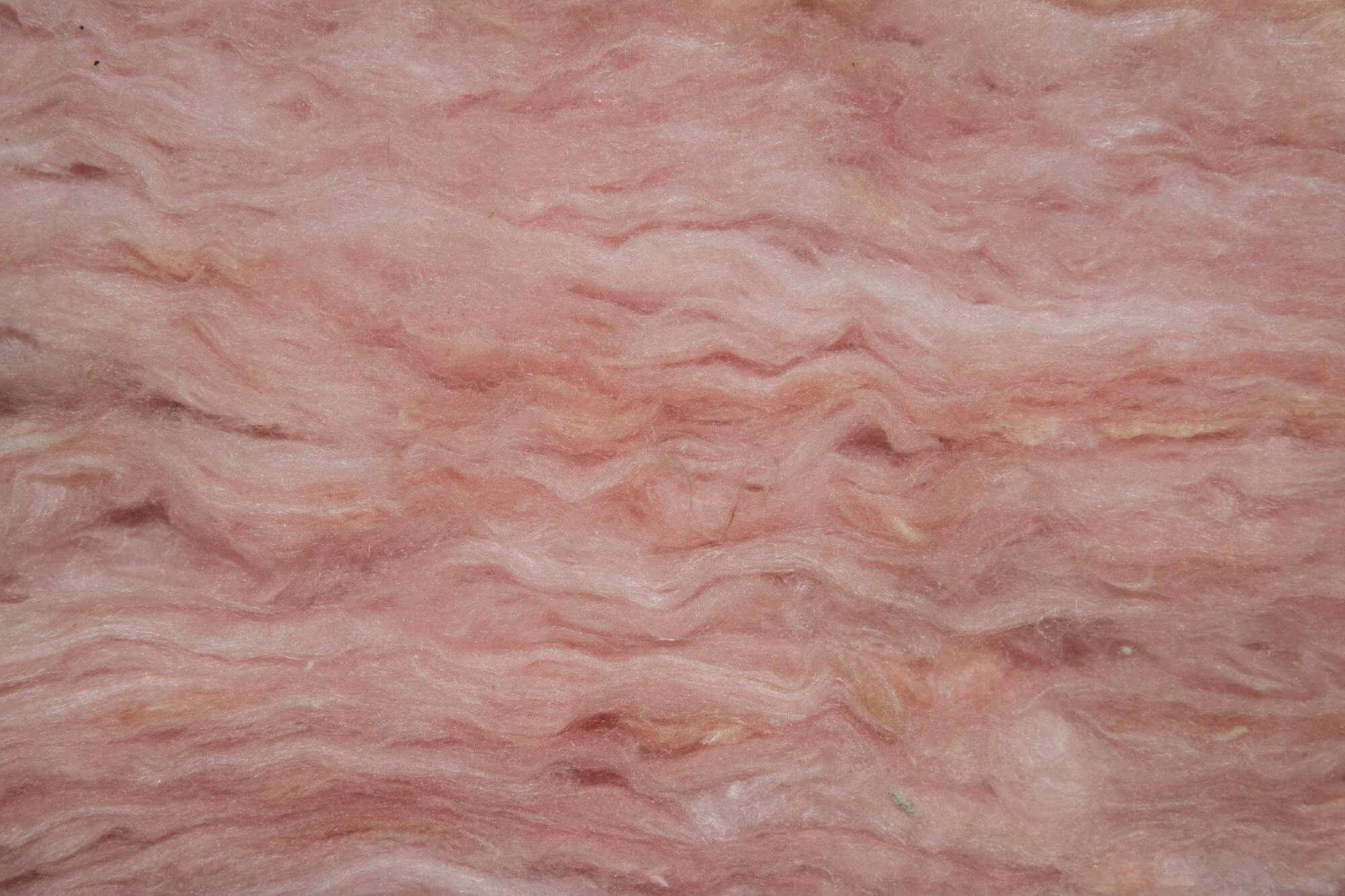 Closeup view of layers of pink fiberglass insulation.