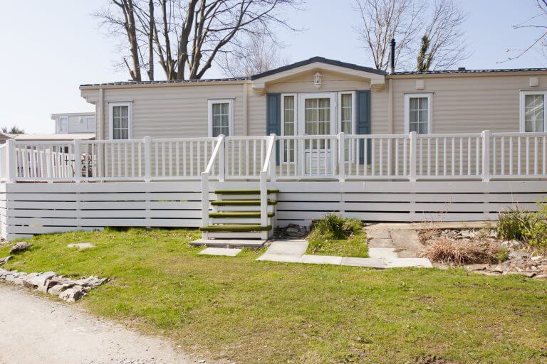 Wooden holiday chalet with veranda, freshly painted and well looked after in Wales, England.