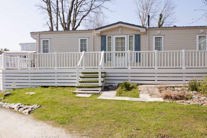 Wooden holiday chalet with veranda, freshly painted and well looked after in Wales, England.