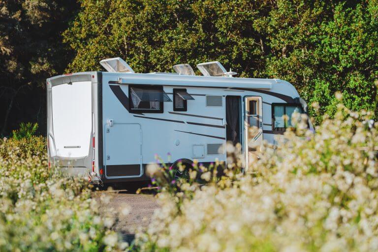 Modern motorhome camper van camping car parked in the nature in free parking and off grid vanlife lifestyle concept. Travel and summer holiday renting vehicle vacation. Green nature park background
