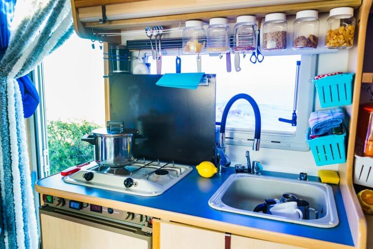 Caravan rv inside, kitchen area. Cooking in campervan. Holidays, adventure with motor home. Van life lifestyle.