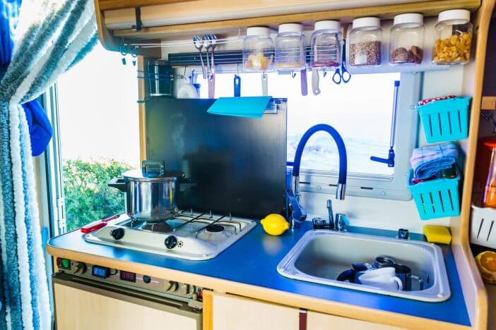 Caravan rv inside, kitchen area. Cooking in campervan. Holidays, adventure with motor home. Van life lifestyle.