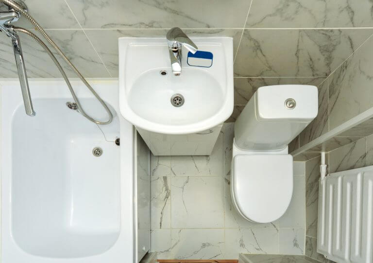 Top view of a small white bathroom. An example of a bathroom in a small apartment space