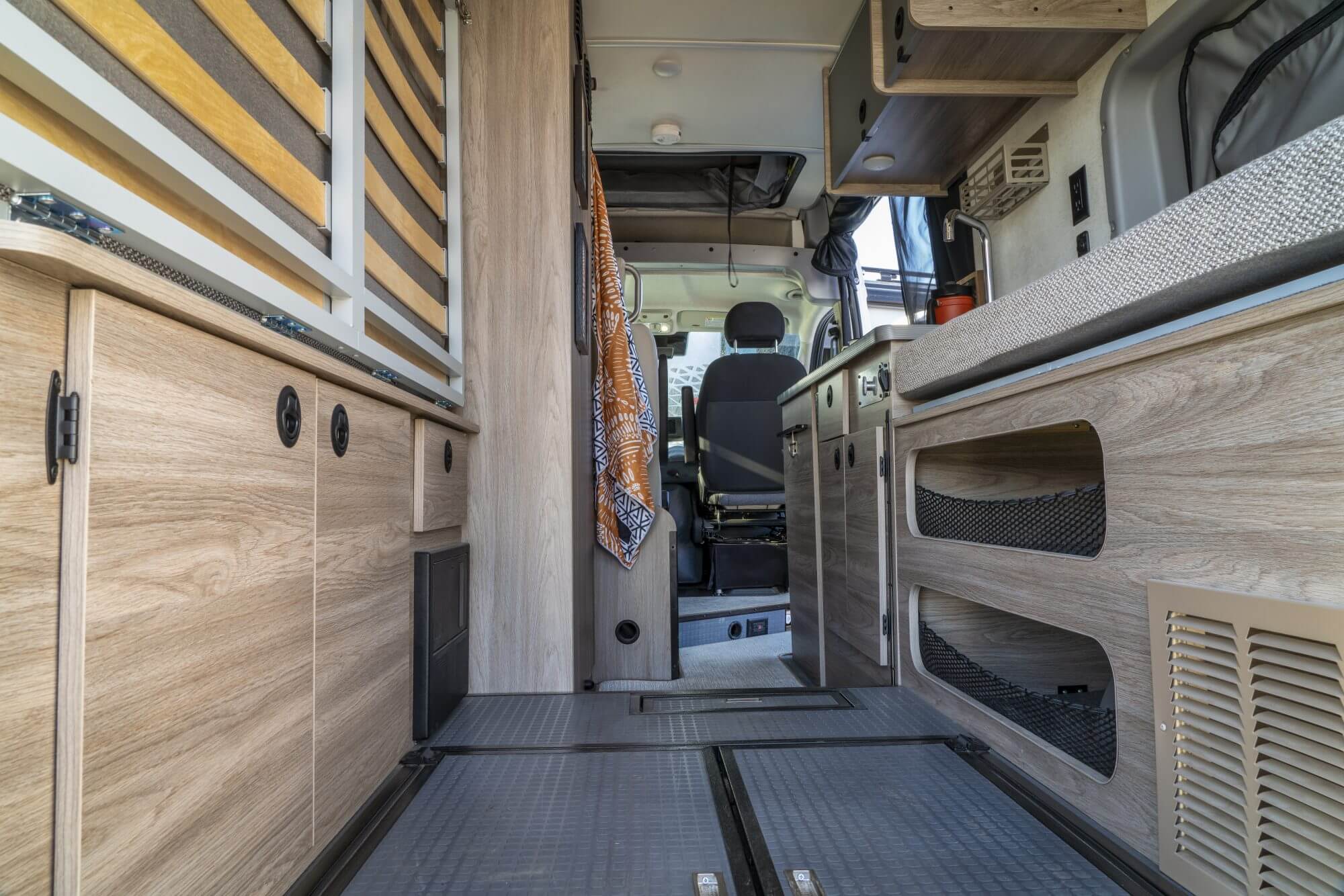 interior of camper van with cargo area, folded bed and kitchen