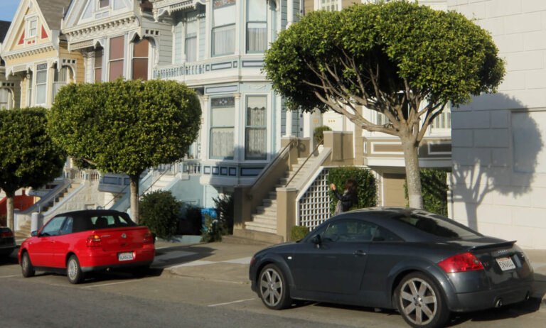 "San Francisco, United States - October 10, 2011: Cars with identifiable number plates and of obvious makes, are parked in front of the picturesque, Queen Anne-style Victorian houses, also known as the Painted Ladies, Postcard Row or the Seven Sisters."