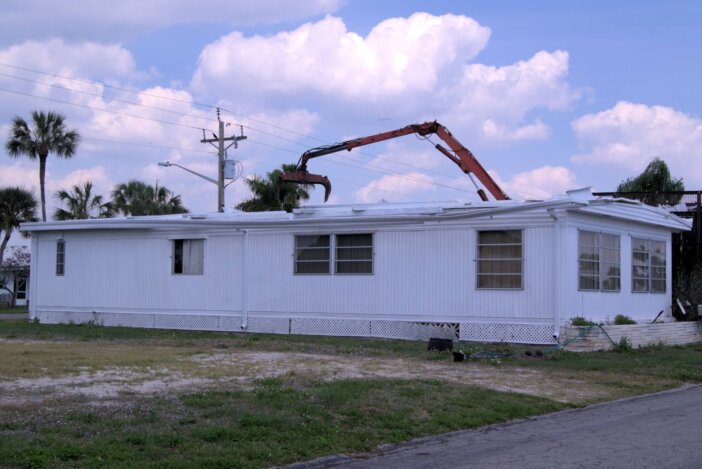 Mobile home being demolished after falling on hard times.