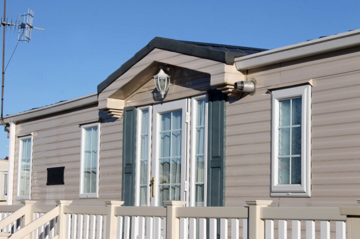 Exterior of luxurious modern caravan with blue sky background.