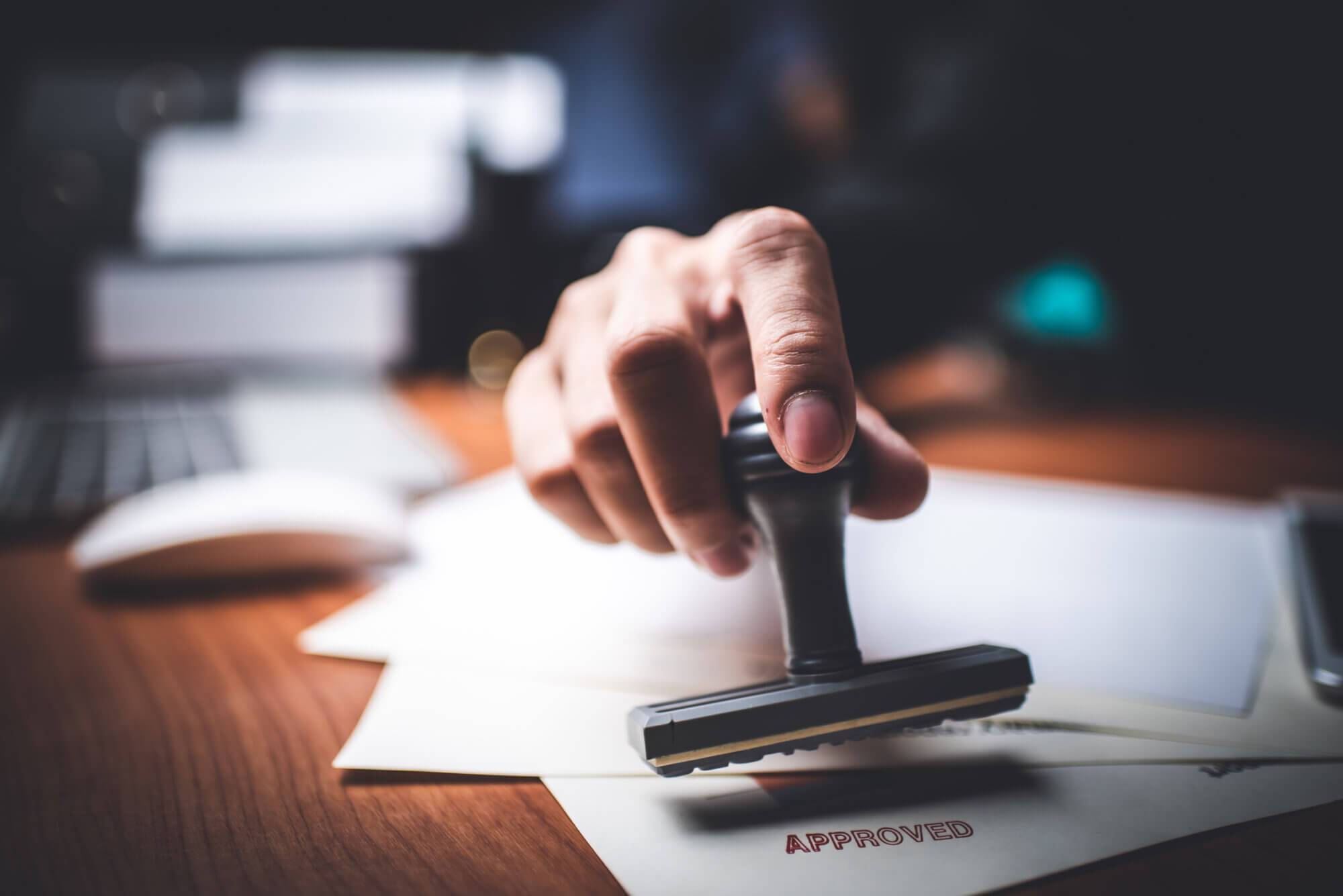 Close-up Of A Person's Hand Stamping With Approved Stamp On Text Approved Document At Desk,  Contract Form Paper